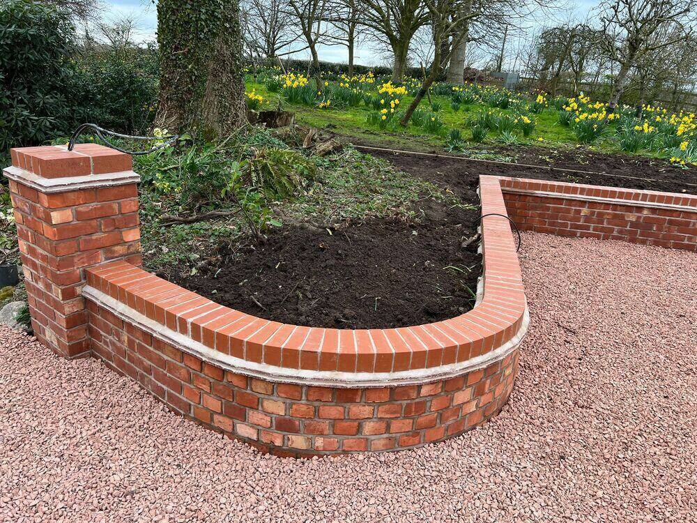 Curved brick boundary wall and entrance pillars