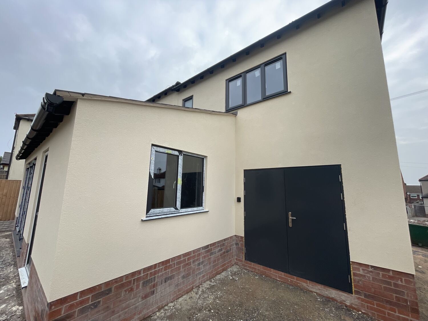 Completed house extension exterior with matching render and brickwork