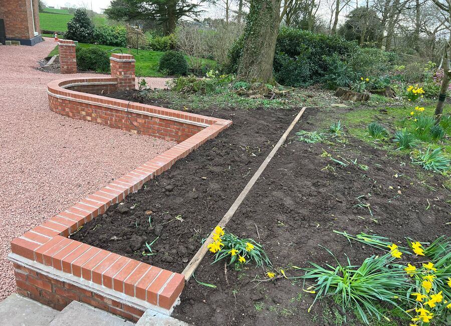 Finished curved brick retaining wall landscaping work in Whitchurch